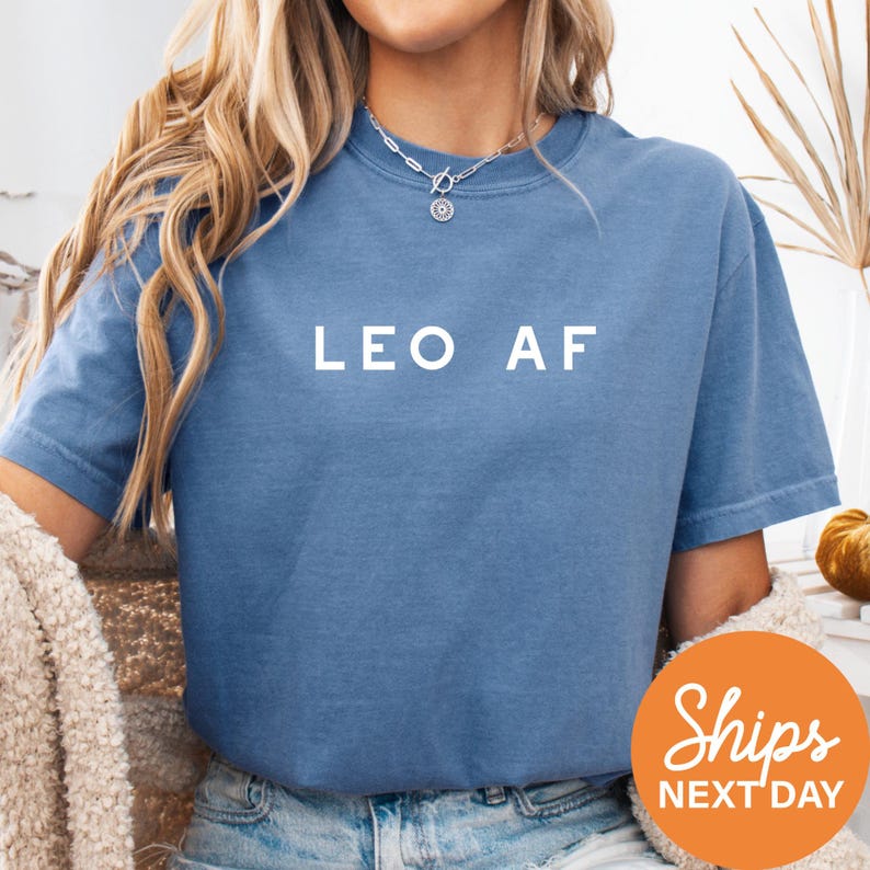 a woman wearing a blue leo af shirt