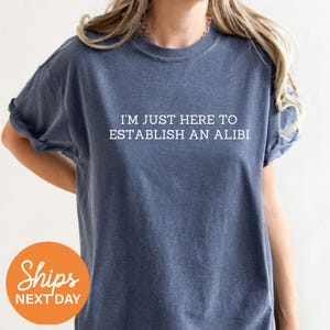 a woman wearing a t - shirt that says, i'm just here to
