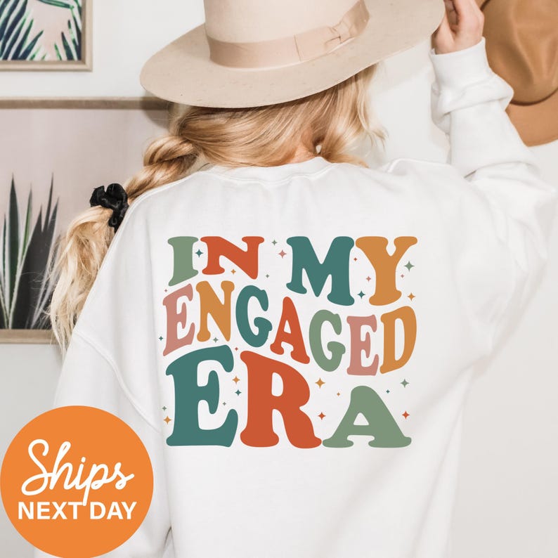 a woman wearing a white shirt that says in my engaged era