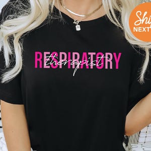 a woman wearing a black shirt with pink lettering