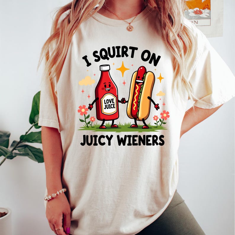 a woman wearing a t - shirt with a hot dog and ketchup on
