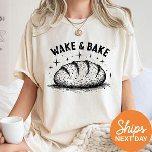 a woman wearing a wake and bake t - shirt while holding a coffee mug