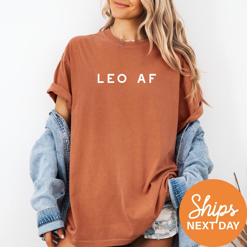 a woman wearing a brown leo af shirt