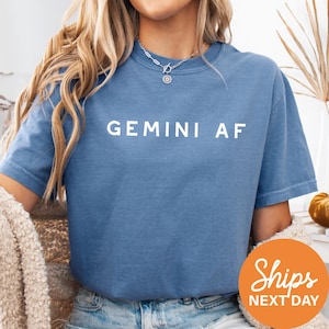 a woman wearing a blue shirt with the word gemin af on it