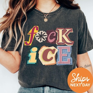 May include: Dark gray t-shirt with the words "f*ck ice" in colorful, layered letters. The text has a vintage, distressed look. The shirt has short sleeves and a round neckline.