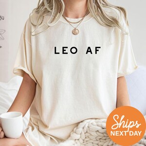 a woman sitting on a bed holding a cup of coffee