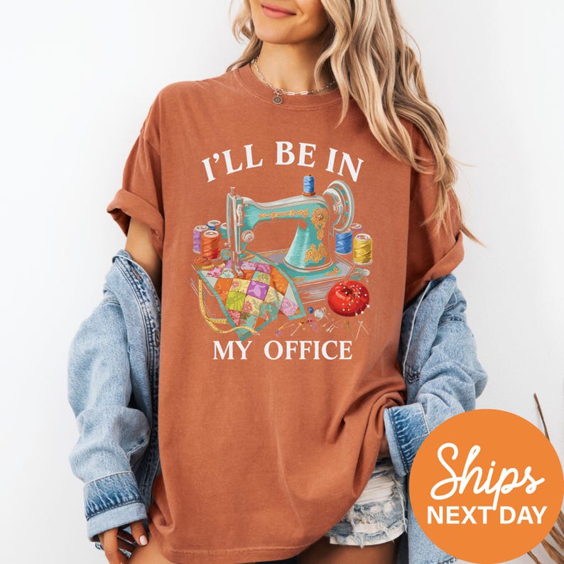 A woman wearing a t-shirt with a sewing machine and sewing supplies, along with the text "I'll be in my office" printed on it.