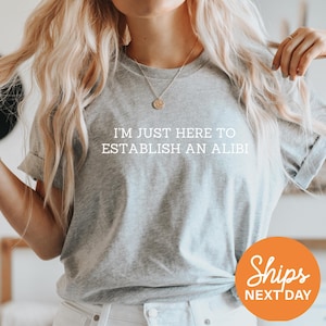 a woman wearing a t - shirt that says, i'm just here to