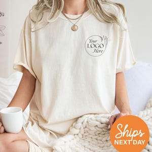 a woman sitting on a bed with a cup of coffee