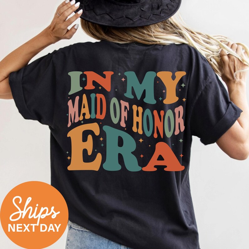 a woman wearing a black t - shirt that says in my mad of honor