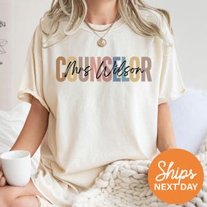 a woman sitting on a bed with a cup of coffee