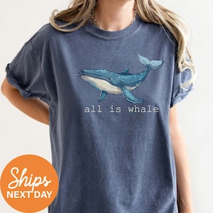 a woman wearing a blue shirt with a whale on it