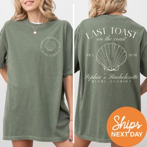 a woman wearing a green t - shirt with a seashell on it