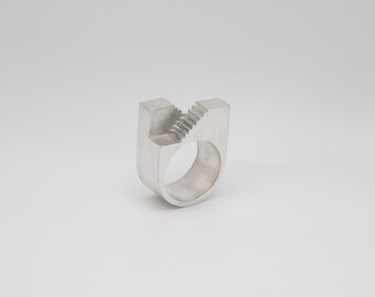 May include: A silver ring with a unique design featuring a series of steps carved into the band.