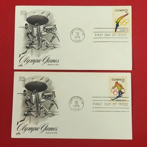 以下が含まれることがあります： オリンピック選手を描いた白黒イラスト、Olympic Games Series of 1976の文字、1976年7月16日のレークプラシッドの消印が押された2枚の初日カバー。各封筒には13セントの米国切手が貼られています。