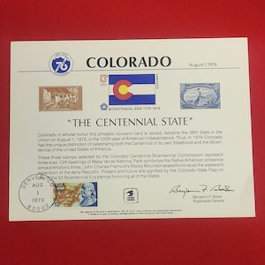May include: A souvenir card commemorating Colorado's Centennial and Bicentennial eras. The card features stamps, the Colorado state flag, and the text "COLORADO" and "THE CENTENNIAL STATE". Includes the date August 1, 1976.