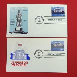 Pode incluir: Dois envelopes brancos do primeiro dia de emissão com o Jefferson Memorial. O envelope superior mostra uma estátua de Jefferson com texto. O envelope inferior apresenta uma ilustração azul do monumento e o texto 2002 Jefferson Memorial.