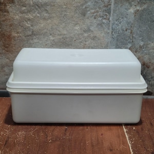 May include: A rectangular white plastic storage container with a matching lid. The container features a smooth, opaque finish and a simple, functional design with rounded corners. The lid sits securely on top of the base, creating a clean, uniform look.