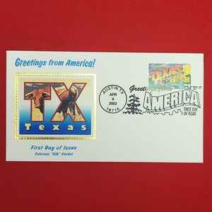 以下が含まれることがあります： Greetings from Americaの切手とColorano Silk Cachetが印刷された白い初日カバー。カシェにはテキサスロングホーンの牛とTXの文字、Texasという単語が描かれています。消印は2002年4月4日、テキサス州オースティンです。