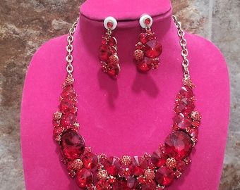 Conjunto vintage de collar y pendientes llamativos con pedrería roja.