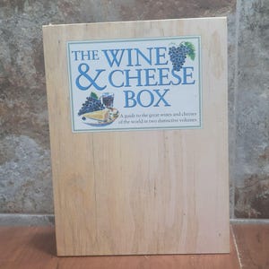 以下が含まれることがあります： 「The Wine & Cheese Box: A guide to the great wines and cheeses of the world in two distinctive volumes」と書かれたラベルが付いた木製の箱です。