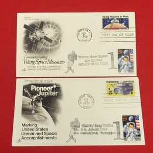 May include: Two white commemorative first day of issue envelopes featuring space exploration themes. The top envelope depicts Viking missions to Mars with a 1978 postmark. The bottom envelope shows Pioneer Jupiter with a 1975 postmark and 29 cent stamps.