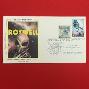 以下が含まれることがあります： エイリアンのイラストと「They're Out There Roswell」の文字が描かれたコロラノ・シルク・カシェ付きの白い記念封筒。パロマー山天文台の切手、UFOの切手、ロズウェル50周年記念の消印が押されています。