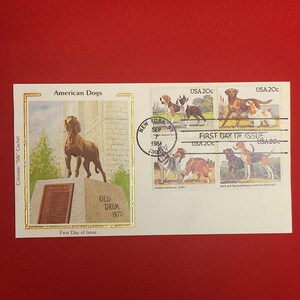 以下が含まれることがあります： 犬の切手とビズラ像の画像が特徴の記念封筒。「USA 20c」とマークされた切手には、さまざまな犬種が描かれています。封筒には「American Dogs」と書かれています。