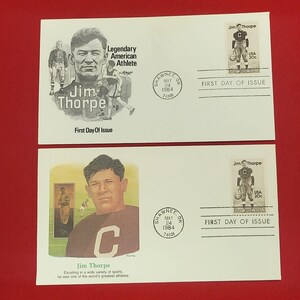 May include: Two white first day of issue envelopes featuring Jim Thorpe. The top envelope has a black and white portrait and illustrations with the text Legendary American Athlete. The bottom envelope features a color portrait and text.