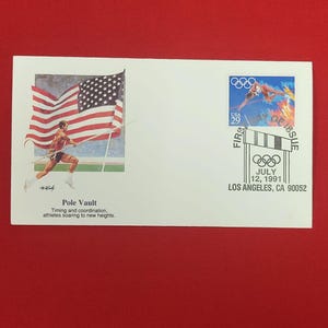 以下が含まれることがあります： アメリカ国旗と棒高跳び選手が描かれた白い初日カバー。29セントのオリンピック切手と「Pole Vault, Timing and coordination, athletes soaring to new heights, July 12, 1991, Los Angeles, CA 90052」という文字が印刷されています。
