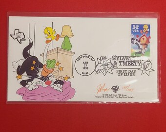 May include: A first day of issue envelope featuring Sylvester and Tweety Bird. The envelope has a cartoon illustration of Sylvester the cat and Tweety Bird. The envelope also has a 32 USA stamp with Sylvester and Tweety.