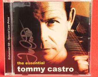 Puede incluir: Una caja de CD con un primer plano del rostro de un hombre y una guitarra. El texto "the essential tommy castro" está en blanco y rojo. El lomo dice "Enhanced CD - Special Low Price".