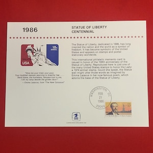 May include: A commemorative philatelic card for the Statue of Liberty Centennial. The card features a stamp with the Statue of Liberty, the text "1986", and the text "USA". The card also includes a quote from Emma Lazarus.