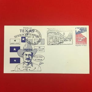 以下が含まれることがあります： A TEXANとラベル付けされたカウボーイハットをかぶった人物の青いインクのイラストが描かれた白い記念封筒。STATE OF TEXAS SESQUICENTENNIALの文字、1986年12月5日のサンアンジェロの消印、22セントのUSA切手が含まれています。
