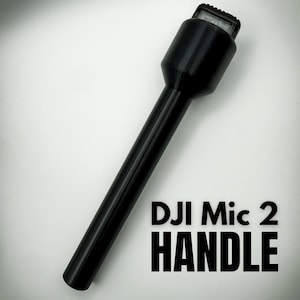 以下が含まれることがあります： 黒色のDJI Mic 2ハンドル。円筒形で、上部にテクスチャ加工が施されています。「DJI Mic 2 HANDLE」の文字が太字の黒で白い背景に表示されています。