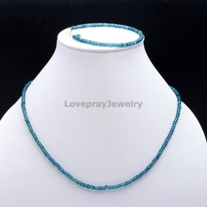 K&ouml;nnte beinhalten: Ein blaues Edelstein-Halsketten- und Armband-Set. Die Halskette und das Armband bestehen aus kleinen, runden Perlen.