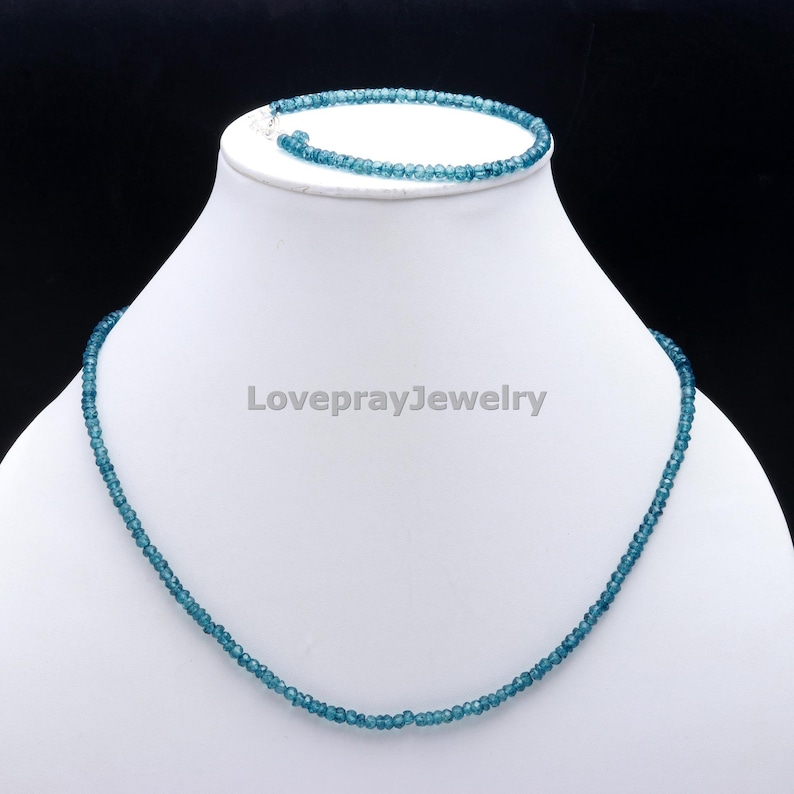 K&ouml;nnte beinhalten: Ein blaues Edelstein-Halsketten- und Armband-Set. Die Halskette und das Armband bestehen aus kleinen, runden Perlen.
