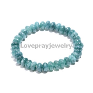 May include: A teal blue gemstone bracelet with round beads. The bracelet is made of natural stones and is approximately 7 inches in length.