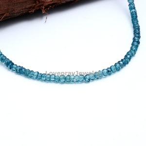 K&ouml;nnte beinhalten: Eine Str&auml;hne blauer Edelsteinperlen. Die Perlen sind facettiert und haben eine leicht unregelm&auml;&szlig;ige Form. Die Perlen sind auf einem durchsichtigen Faden aufgef&auml;delt.