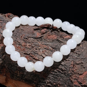 May include: White gemstone bracelet with round beads. The bracelet is made of natural white stones and is approximately 7 inches in length.