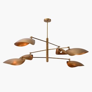 Peut inclure: Un lustre moderne en laiton avec six abat-jours en forme de feuilles. Les abat-jours ont un intérieur doré et chaud et sont suspendus à des bras articulés. Le luminaire est conçu pour un montage au plafond et a une esthétique minimaliste.