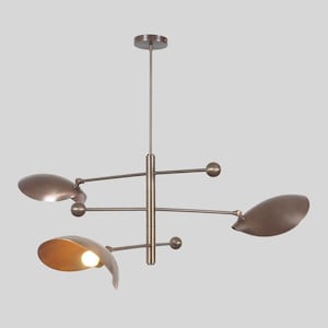 Puede incluir: Una lámpara colgante moderna de color bronce con cuatro brazos ajustables y pantallas. Las pantallas están inclinadas y tienen una forma ligeramente curvada.