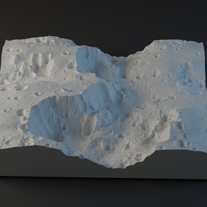 Op de afbeelding: Een wit, 3D-geprint model van een maanlandschap met kraters en valleien. Het model staat op een grijze basis.