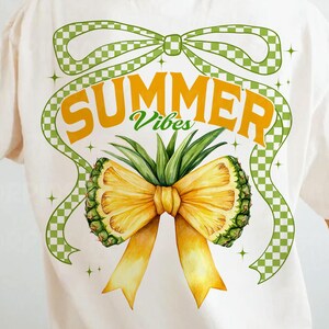 May include: White t-shirt with a green and white checkered bow and a pineapple bow with the text "SUMMER Vibes" in yellow letters.