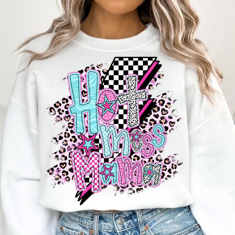 May include: White sweatshirt with a graphic design that says "Hot Mess Mama" in pink, blue, and black letters with a checkered pattern and leopard print accents.