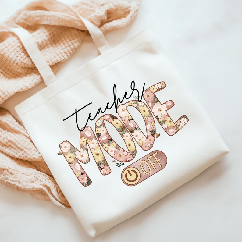 May include: White canvas tote bag with the text "Teacher Mode Off" in black script. The word "Mode" is decorated with pink and yellow floral designs. A power button icon is next to the text "Off".