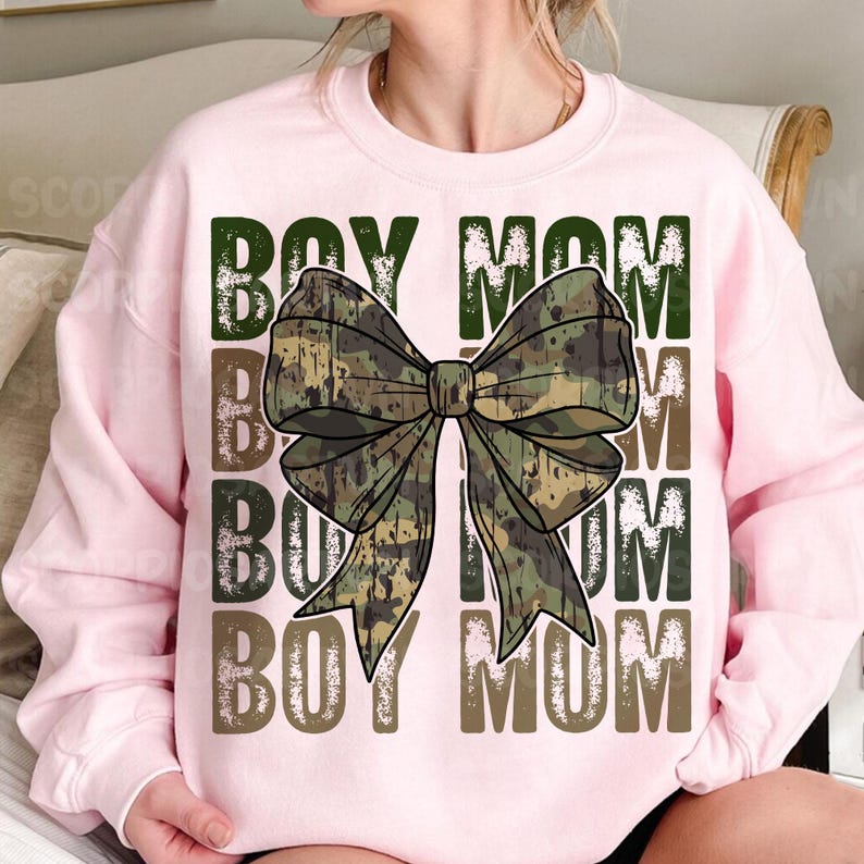 May include: Pink sweatshirt with a camouflage bow and the text "Boy Mom" repeated four times in a distressed font.