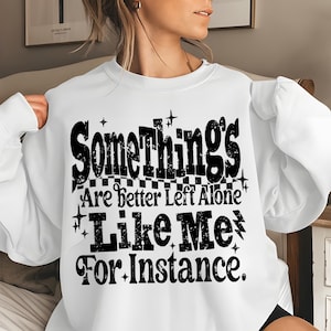 May include: White sweatshirt with the text "Somethings Are better Left Alone Like Me For Instance" in black. The text has a distressed, vintage style. The sweatshirt is a crew neck style.