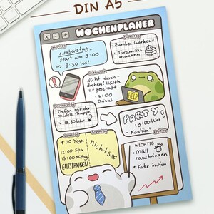 May include: A DIN A5 weekly planner sheet with a light blue border, featuring a digital interface design. It includes handwritten German text, cartoon illustrations of a frog and a character with a tie, and sections for daily tasks and notes.