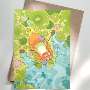 May include: A whimsical illustration of a frog in an orange boat, floating on a pond with lily pads and dragonflies. The frog is wearing a life preserver. The pond has blue water and is surrounded by green lily pads and pink flowers. The illustration is on a greeting card.